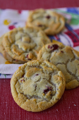 Soft and chewy white chocolate cranberry cookies on a red and white checkered cloth.