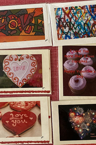 Collection of Valentine's Day themed items including greeting cards with abstract art and graffiti-style 'Love' text, heart-shaped cookies with 'Love You' icing, and cupcakes with purple frosting and 'Love You More' text.