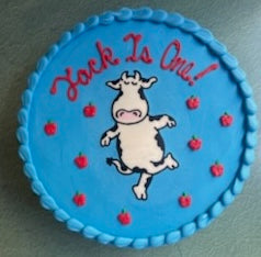 Blue cookie with 'Jack is One!' text and cow illustration on a white background