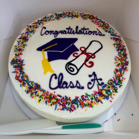 Graduation-themed cake with colorful sprinkles and a diploma design on a white background.