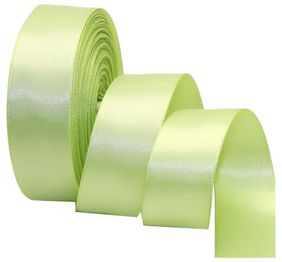 A large spool of shiny, light green satin ribbon with several loops unwound, presented on a white background.