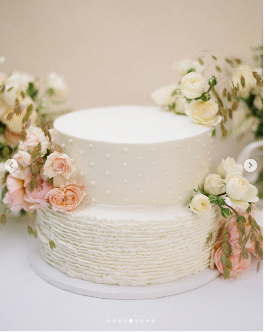 White wedding cake with floral decorations on a light background