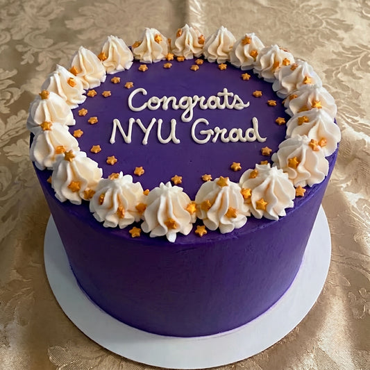 Bold Purple cake with decorative white frosting and gold stars on a gold patterned tablecloth