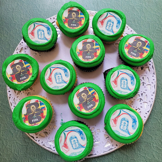 Cupcakes with green frosting and FIFA-themed decorations on a decorative plate.